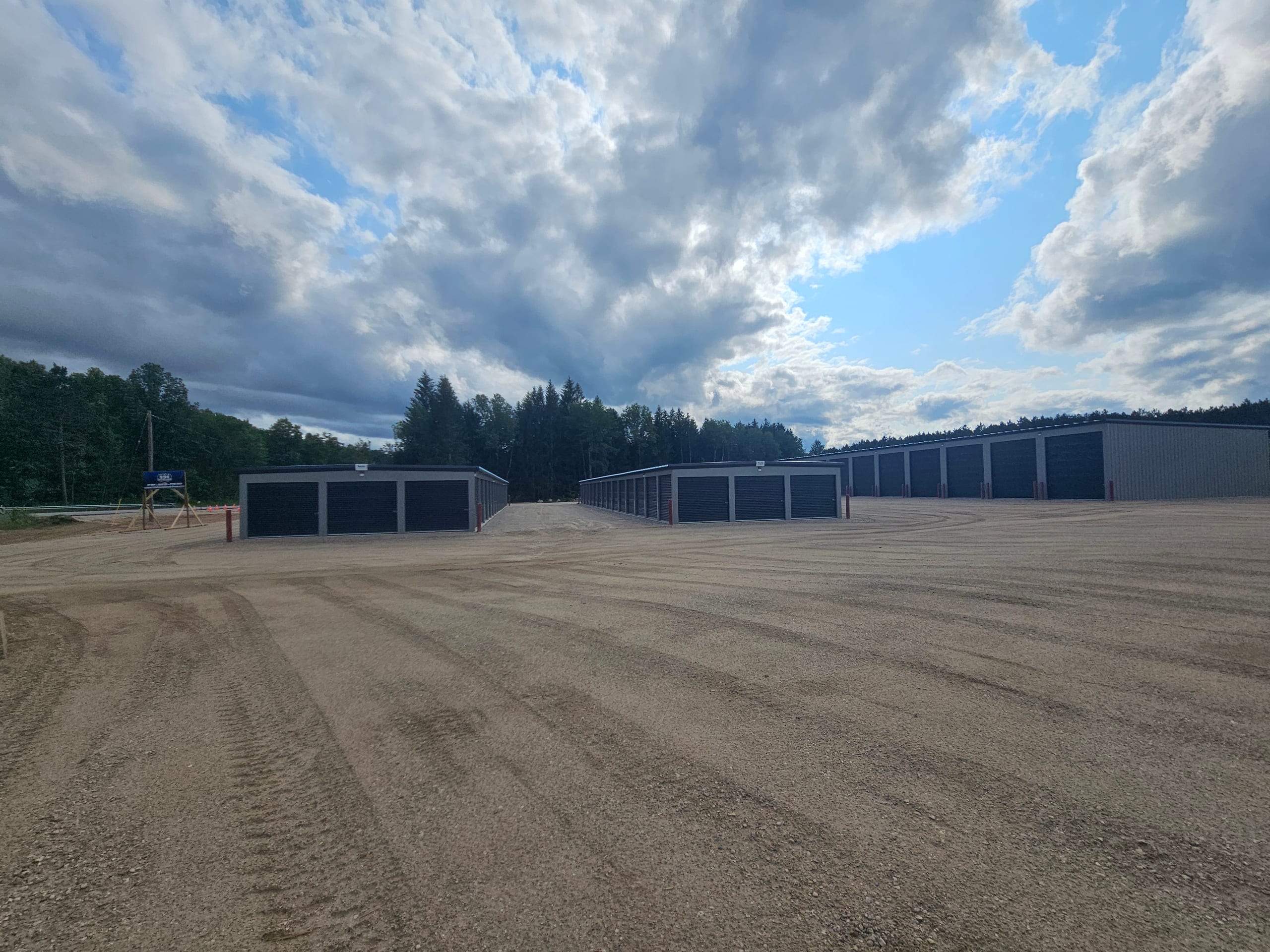 Rows of storage unit buildings under a cloudy sky at 131 Storage Solutions